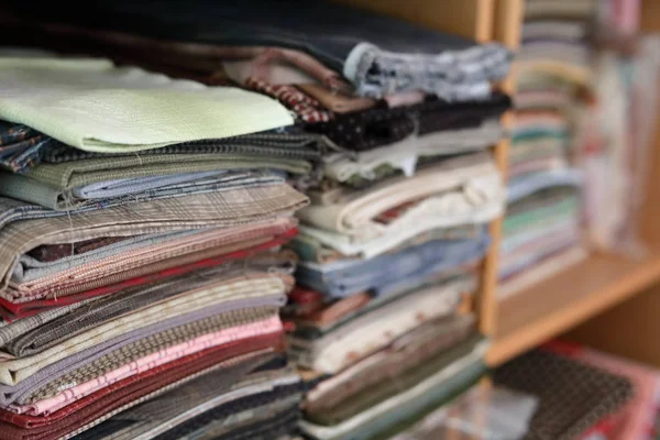 Pile de pièces tissu beaucoup de modèle sur l'étagère, recyclage des matériaux pour la conception de mode de vêtements — Photo