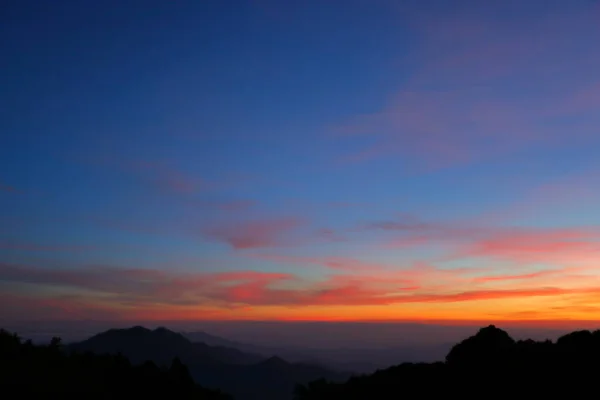 Paisaje bosque de montaña en la niebla con el cielo puesta del sol en la naturaleza mística — Foto de Stock