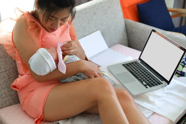 Zakenvrouw werken met laptop computer en haar baby slapen in huis business office — Stockfoto