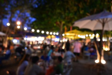 İnsanlar gece parti festivalinde ampul asılmış bahçe festivalinde kalabalıklar.