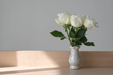 Evde beyaz gül çiçeği süslemesi, küçük vazoda açan güzel bir çiçek.