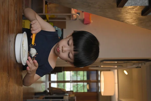 Niedlichen Jungen essen Essen Sie selbst Spaß haben — Stockfoto