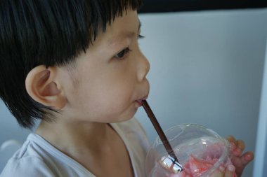 Mutlu şirin çocuk çilekli meyve suyu iç.