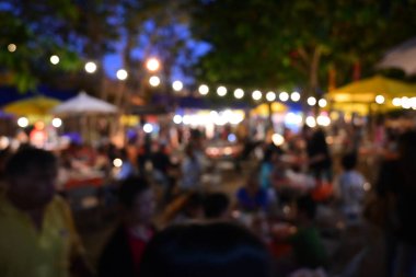 İnsanlar gece parti festivalinde ampul asılmış bahçe festivalinde kalabalıklar.