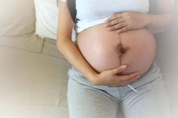 Mãe mão segurar abraçando barriga grávida de amor por um bebê — Fotografia de Stock