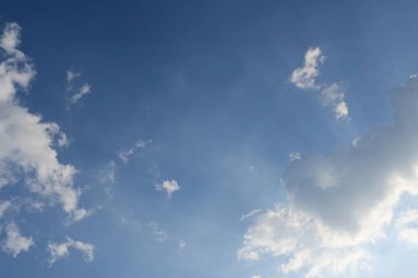 Mavi gökyüzünün üstündeki kabarık bulutlar Sabah güneş ışığıyla