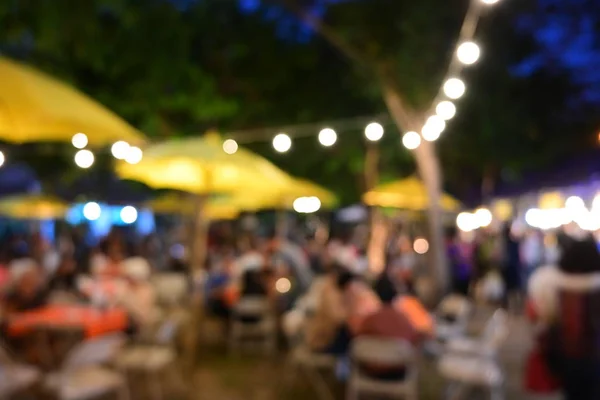 Pessoas multidão na noite festa festival de jardim ao ar livre com lâmpada pendurada decoração — Fotografia de Stock