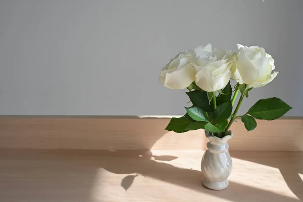Biały kwiat róży dekoracji w domu, piękny kwiat kwitnący w małym wazonie umieścić na drewnianym stole — Zdjęcie stockowe