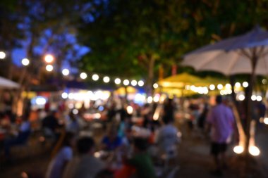 İnsanlar gece parti festivalinde ampul asılmış bahçe festivalinde kalabalıklar.