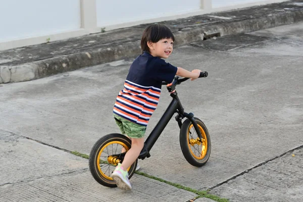 Симпатичный мальчик на велосипеде баланса на улице весело провести время — стоковое фото