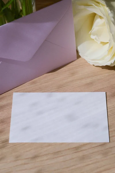 Blank white paper of wedding card put on wooden table with romantic rose flower in morning day — Stock Photo, Image