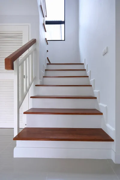 Коричневая деревянная лестница и белая стена в жилом доме — стоковое фото