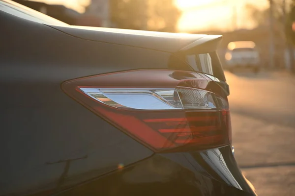 Closeup cauda luz de carro moderno preto na cena da manhã — Fotografia de Stock