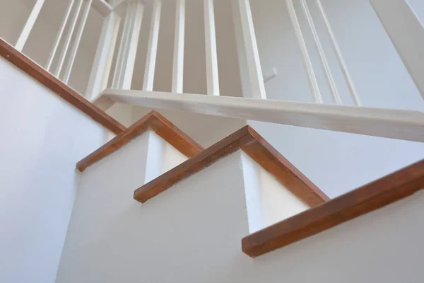 Escalera de madera marrón con barandilla de acero blanco y pasamanos de madera dura en casa residencial moderna — Foto de Stock