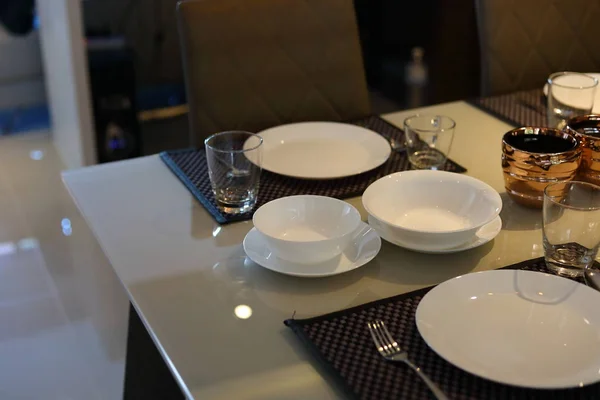 white dish ware sets arrange on dinner table inside eating room of modern home interior