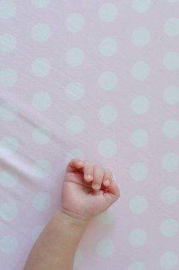 Pembe arka planda küçük bir bebek eli