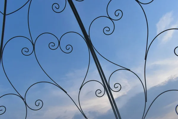 Heart shape of curve steel wire in outdoor garden decoration with blue sky background — 스톡 사진