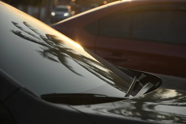 Viagem de carro moderno preto pela manhã com reflexo de palmeira no pára-brisas — Fotografia de Stock