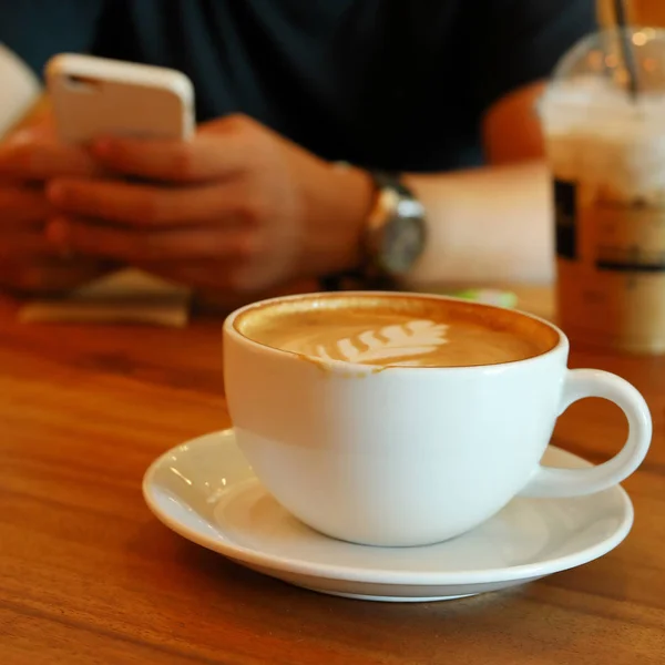 Bebida de café quente no café e as pessoas que trabalham no telefone celular aplicativo inteligente — Fotografia de Stock