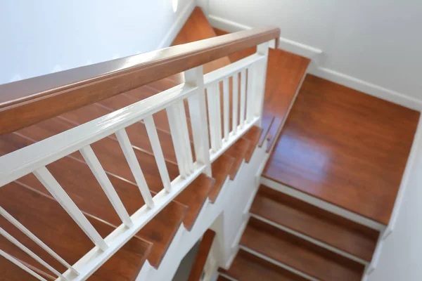 Poręcz z drewna liściastego i balustrada ze stali białej na brązowych drewnianych schodach dekorowane wnętrze — Zdjęcie stockowe