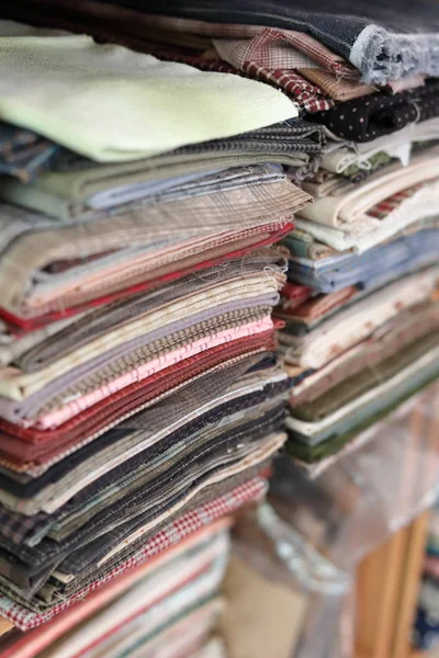 Pile de pièces tissu beaucoup de modèle sur l'étagère, recyclage des matériaux pour la conception de mode de vêtements — Photo