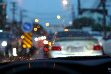 Gece yolundaki trafik sıkışıklığı. Yağmurlu bir günde hava durumu. Sokakta yağmur damlalarıyla araba sürmek.