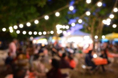 İnsanlar gece parti festivalinde ampul asılmış bahçe festivalinde kalabalıklar.
