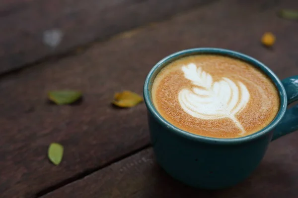 Sıcak latte kahve içeceği. Sabahları ahşap masaya konur. — Stok fotoğraf