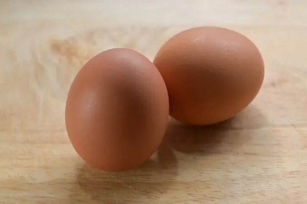 Mutfaktaki tahta kesme tahtasına konmuş tavuk yumurtası. — Stok fotoğraf