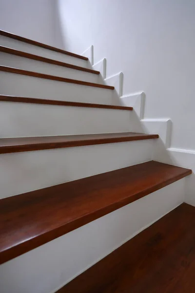 Hnědé dřevěné schodiště a bílá zeď v obytném domě — Stock fotografie