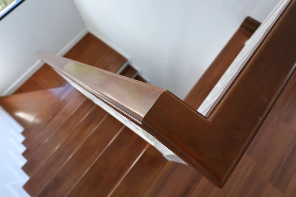 Poręcz z drewna liściastego na brązowych drewnianych schodach wnętrza urządzone w nowoczesnym stylu domu mieszkalnego — Zdjęcie stockowe