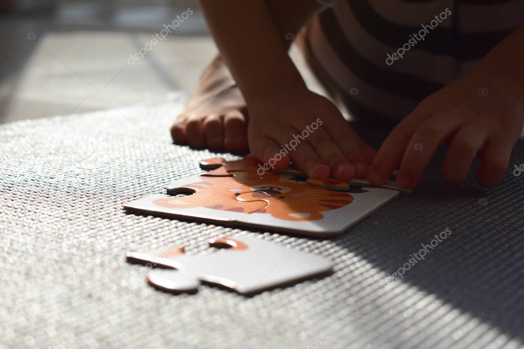 cute baby preschool playing jigsaw puzzle learning in playroom