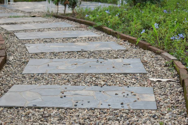 Stone block pathway in flower garden — Stock Photo, Image