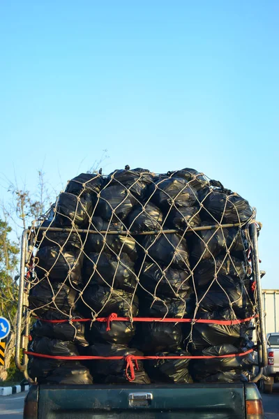 Heap of black garbage bag plastic on back pick-up truck vehicle car — Stock Photo, Image