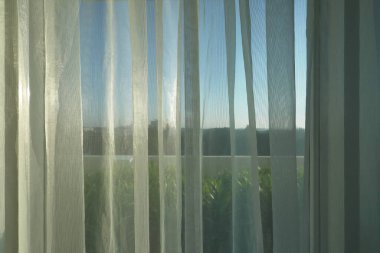 pencerede beyaz perde ile sabah güneş ışığı