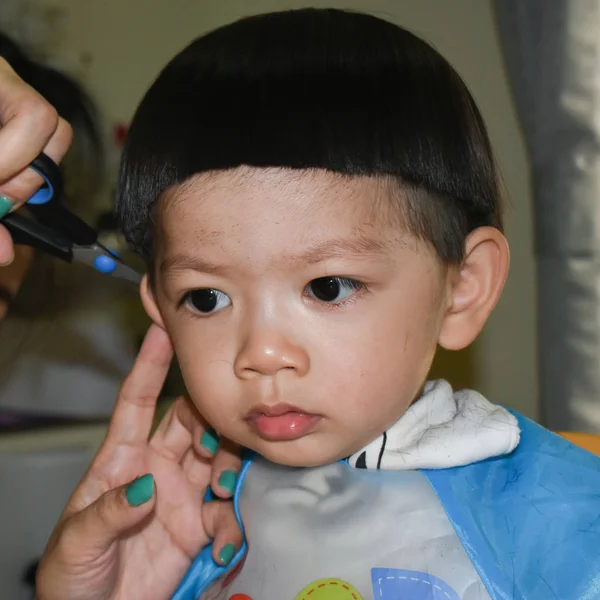 Mother hairdresser using scissor haircut a cute baby boy in home — 스톡 사진