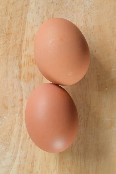 Huevo de gallina poner en la tabla de cortar madera en la cocina preparar la cocina —  Fotos de Stock