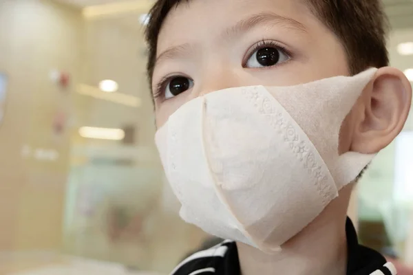 Schattig kind dragen hygiënisch gezichtsmasker bescherming zorg je zelf tegen ziekte verspreid infectie en luchtvervuiling — Stockfoto
