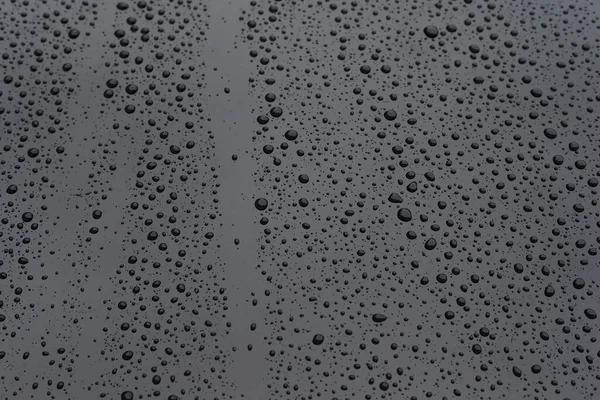 Gota de lluvia de agua en el coche moderno vehículo negro con recubrimiento de vidrio brillante — Foto de Stock