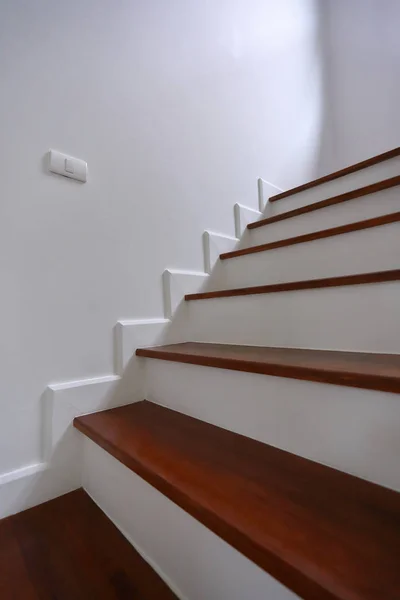 Коричневая деревянная лестница и белая стена в жилом доме — стоковое фото