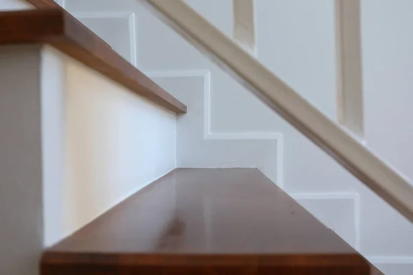 Hnědé dřevěné schodiště a bílá stěna v moderním obytném domě — Stock fotografie
