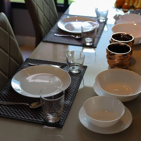 Комплекты посуды организовать на завтрак стол утром внутри столовой современного интерьера дома — стоковое фото