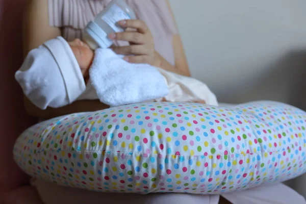 Madre criando a su hijo, mamá amamantando a un bebé recién nacido chupando leche del biberón — Foto de Stock