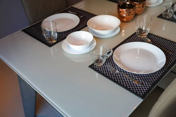 white dish ware sets arrange on dinner table inside eating room of modern home interior