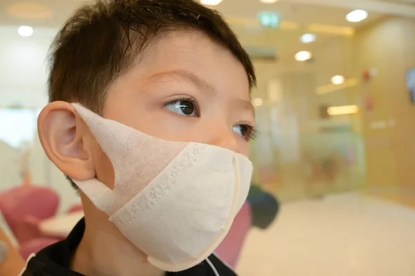 Yakışıklı çocuk hijyenik yüz maskesi takıyor. Kendini hastalıktan, enfeksiyondan ve hava kirliliğinden koru. — Stok fotoğraf