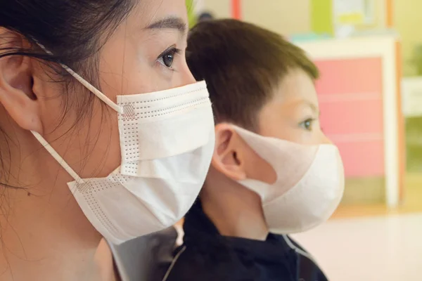Kadın ve oğul hijyenik yüz maskesi takıyor. Hastalıktan, enfeksiyondan ve hava kirliliğinden korunuyor. — Stok fotoğraf
