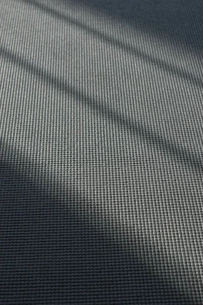 Esterilla de yoga puesta en el suelo en gimnasio de fitness lateral, fondo de ejercicio deportivo de imagen con luz solar en el día de la mañana — Foto de Stock