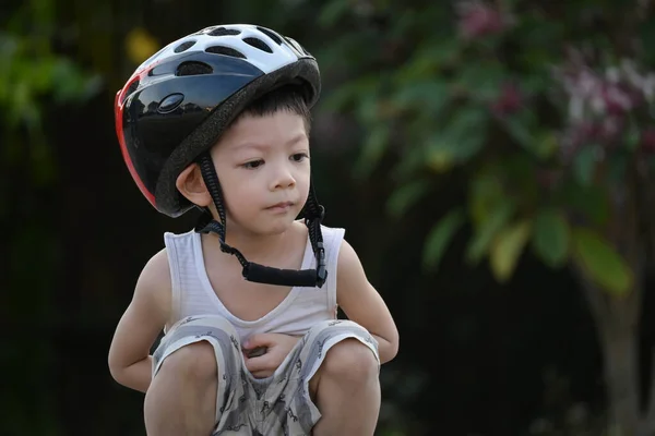 귀여운 아이는 공원에서 자전거를 스포츠 헬멧을 다닌다 — 스톡 사진