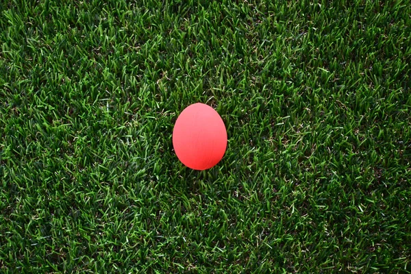 芝生の上の赤いイースターエッグ緑の芝生の人工的なイメージ春の朝のコンセプトの背景 — ストック写真