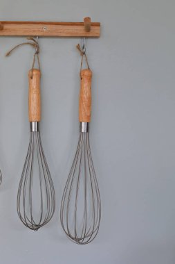 Mutfak odasındaki duvarda mutfak malzemeleri asılı.